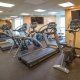 A fitness room with treadmill and cycle
